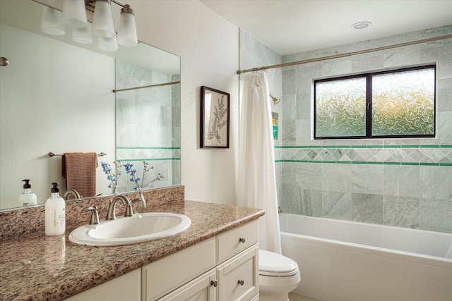 bathroom featuring toilet, shower / bath combo with shower curtain, and vanity