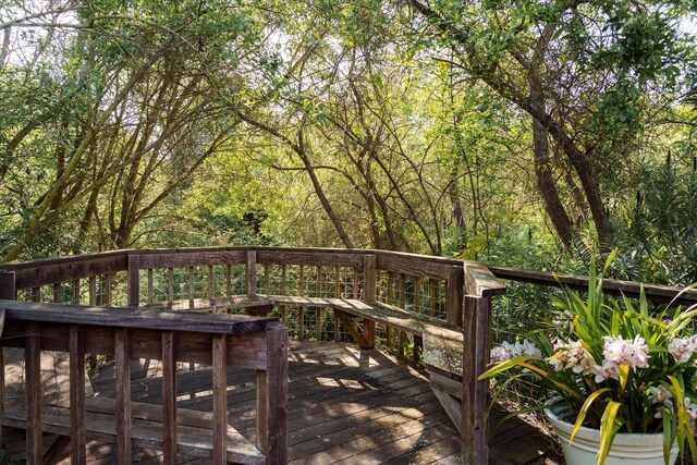 wooden terrace featuring a wooded view