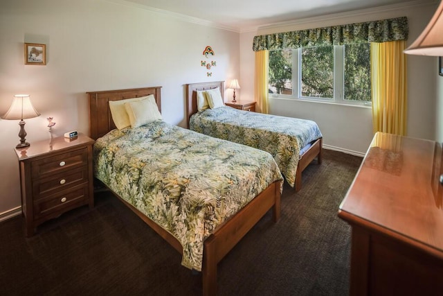bedroom featuring dark carpet, crown molding, and baseboards