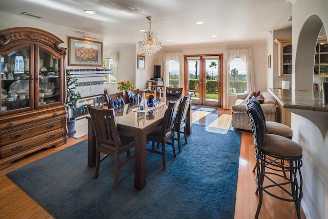 dining room with crown molding, wood finished floors, and visible vents