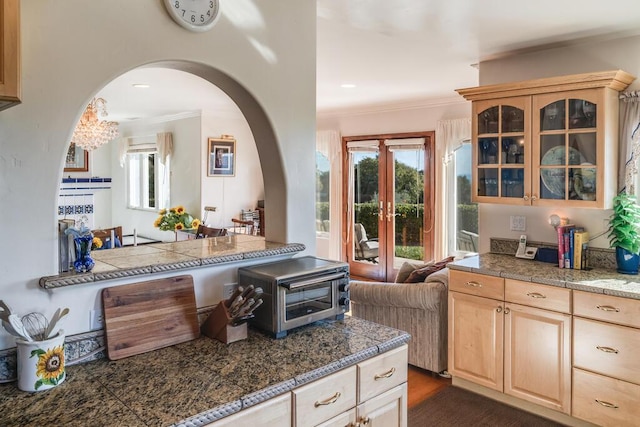 kitchen featuring french doors, tile counters, light brown cabinetry, and glass insert cabinets