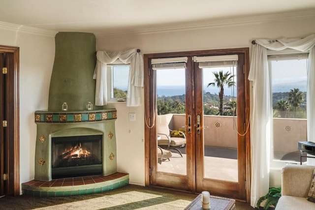 entryway featuring crown molding, french doors, carpet flooring, and a fireplace