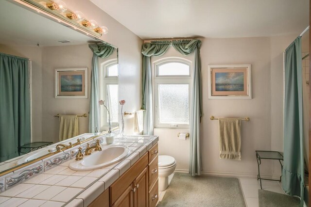 full bath featuring toilet, vanity, baseboards, and visible vents