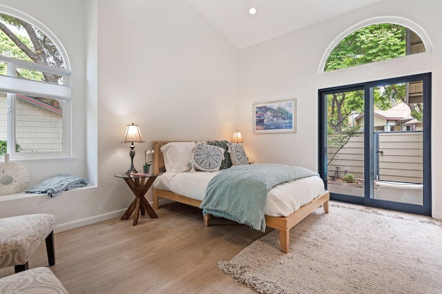 bedroom featuring recessed lighting, light wood-style floors, access to exterior, baseboards, and high vaulted ceiling