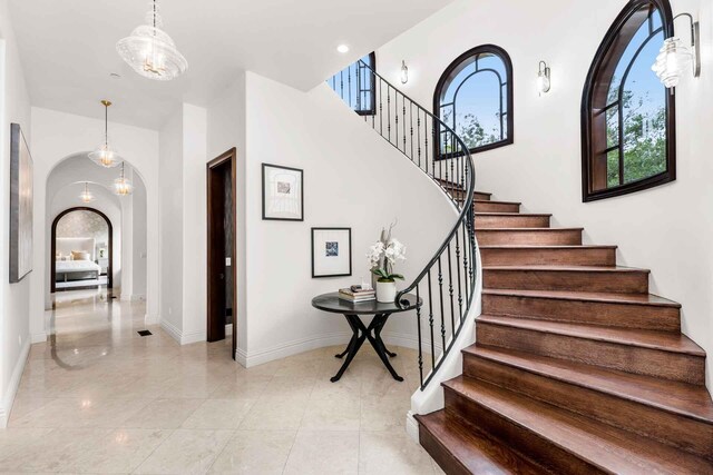 2084 E Valley Rd Unit 1, Santa Barbara, CA 93108 - staircase with a chandelier, arched walkways, and baseboards