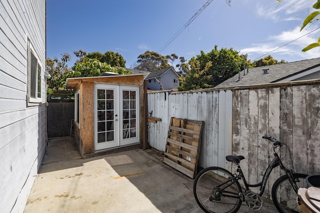 view of outbuilding featuring a fenced backyard, an outdoor structure, and french doors