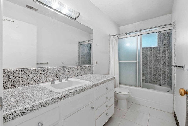 bathroom with shower / bath combination with glass door, vanity, tile patterned floors, toilet, and visible vents