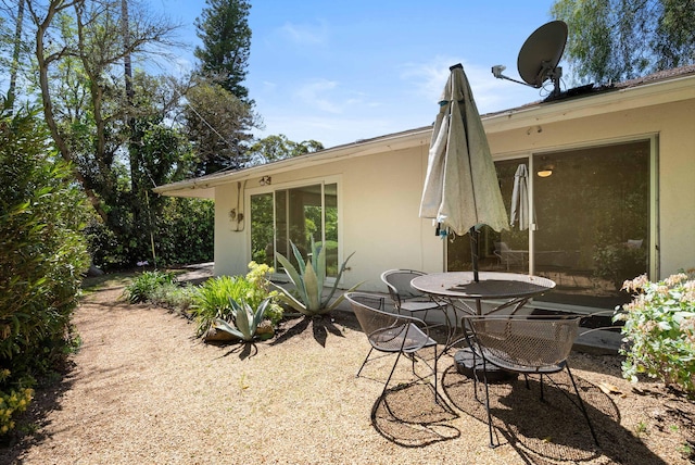 rear view of property featuring a patio and stucco siding