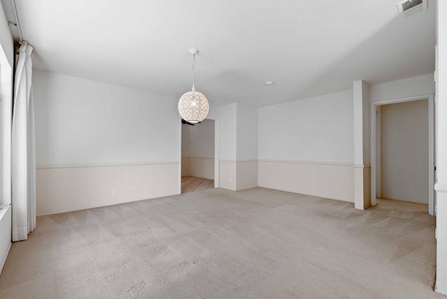carpeted empty room featuring visible vents