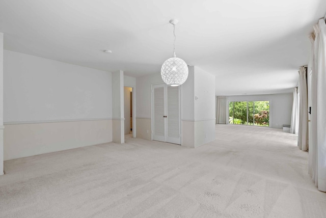 spare room featuring an inviting chandelier and carpet