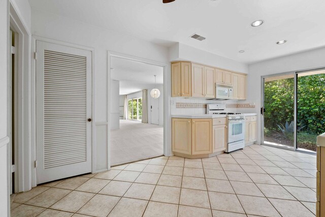 kitchen featuring white appliances, visible vents, light brown cabinets, and light countertops