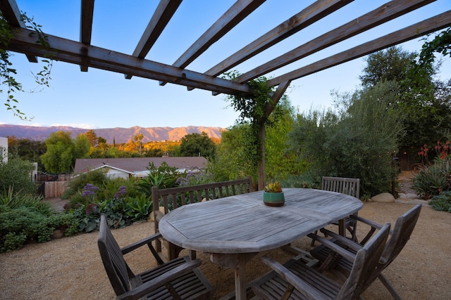 view of patio / terrace with outdoor dining area, a mountain view, fence, and a pergola