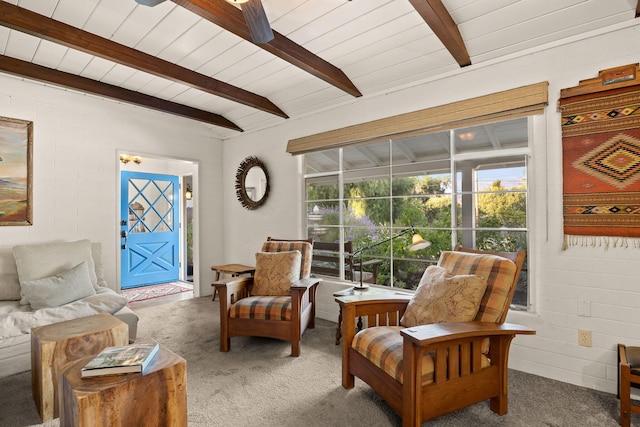 sitting room featuring beamed ceiling, carpet flooring, and a ceiling fan