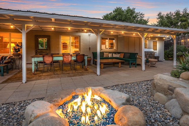 rear view of property featuring an outdoor fire pit and a patio