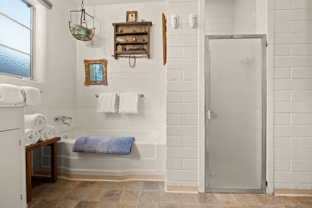 bathroom featuring a bath and a shower stall