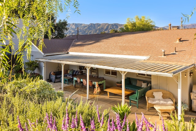 rear view of property with outdoor lounge area, a patio, and a mountain view