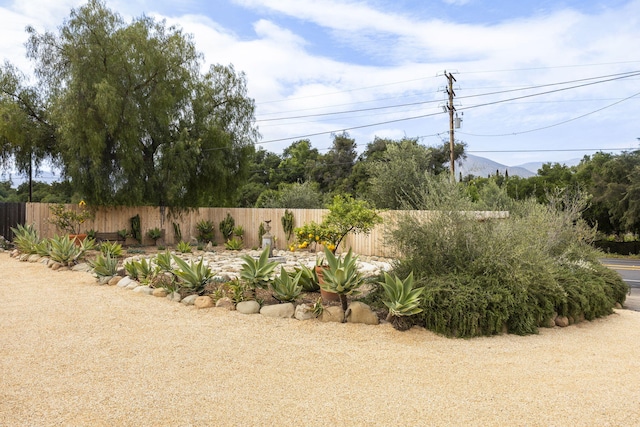 view of yard featuring fence and a mountain view