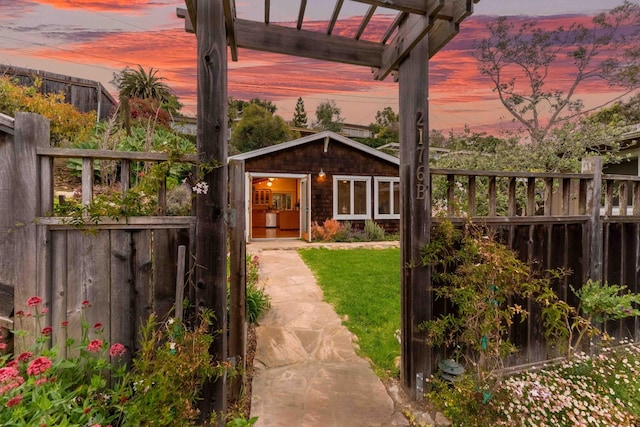 exterior space featuring fence, a gate, and a lawn