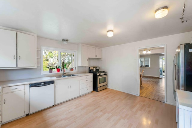 kitchen featuring white cabinetry, a sink, stainless steel appliances, light countertops, and light wood-type flooring