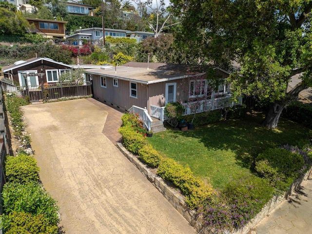 single story home featuring fence, concrete driveway, a front yard, and a porch