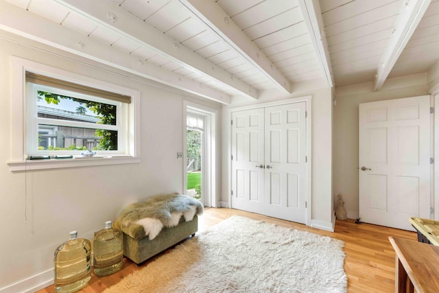 sitting room with beam ceiling, light wood-type flooring, wood ceiling, and baseboards