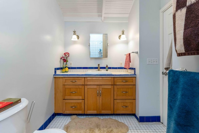 bathroom featuring toilet, tile patterned floors, vanity, and baseboards