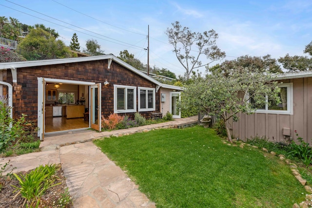 rear view of house featuring a yard and board and batten siding