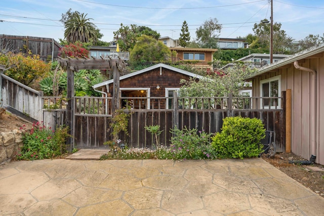 back of property with a pergola, fence private yard, board and batten siding, and a patio area