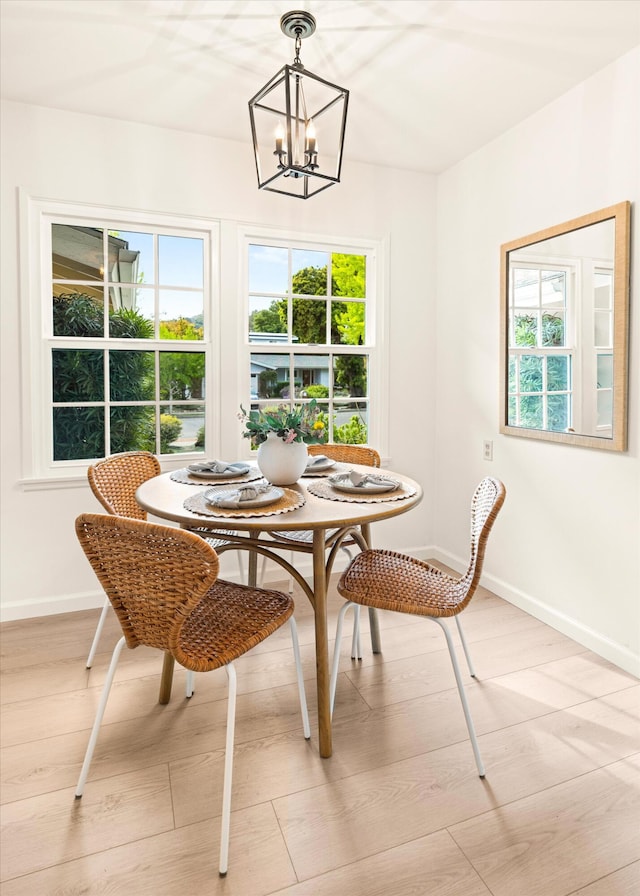 dining space featuring baseboards, plenty of natural light, an inviting chandelier, and breakfast area