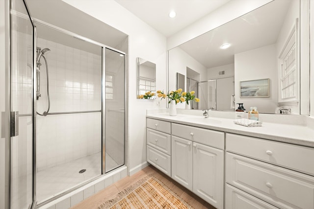 bathroom featuring visible vents, recessed lighting, vanity, wood finished floors, and a stall shower