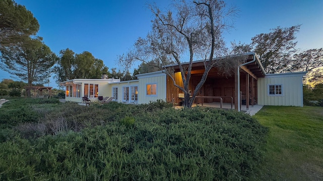 2852 Tapadero Rd, Solvang, CA 93463 - back of house with board and batten siding, a lawn, a sunroom, and a patio