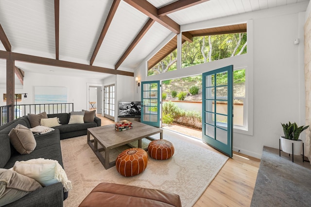 living area with high vaulted ceiling, baseboards, light wood-style floors, and beamed ceiling