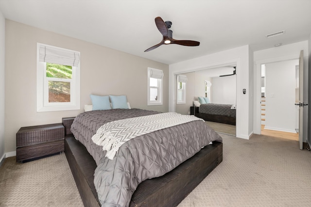 carpeted bedroom with a closet, visible vents, baseboards, and ceiling fan