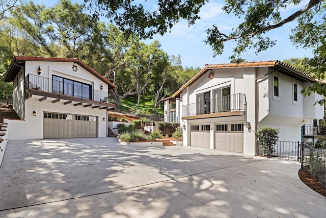 mediterranean / spanish-style home with driveway, a balcony, and a garage