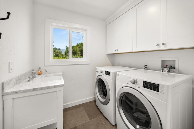 laundry area with baseboards, cabinet space, a sink, and washing machine and clothes dryer