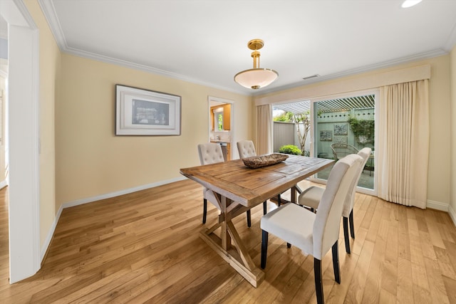 dining area featuring crown molding, baseboards, light wood finished floors, and visible vents