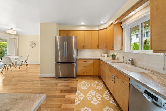 kitchen with stainless steel appliances, baseboards, light wood-type flooring, and tasteful backsplash