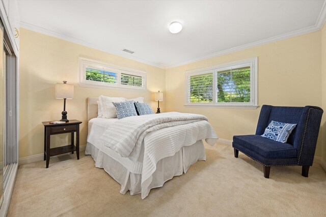 bedroom with crown molding, baseboards, and light colored carpet