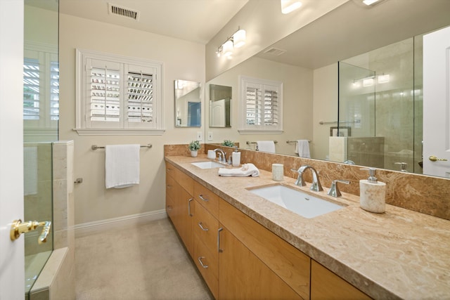 full bathroom with a sink, baseboards, a shower with shower door, and visible vents
