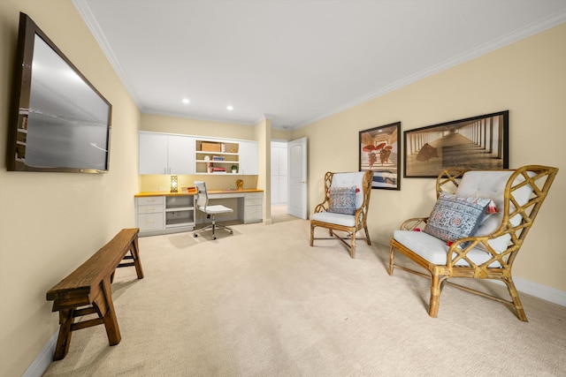 sitting room with crown molding, baseboards, built in study area, and light colored carpet