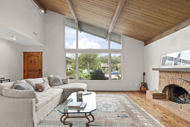living area featuring wood finished floors, wooden ceiling, beamed ceiling, a fireplace, and high vaulted ceiling