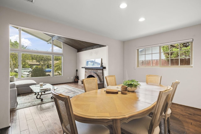 dining area with recessed lighting, a brick fireplace, wood finished floors, and a healthy amount of sunlight