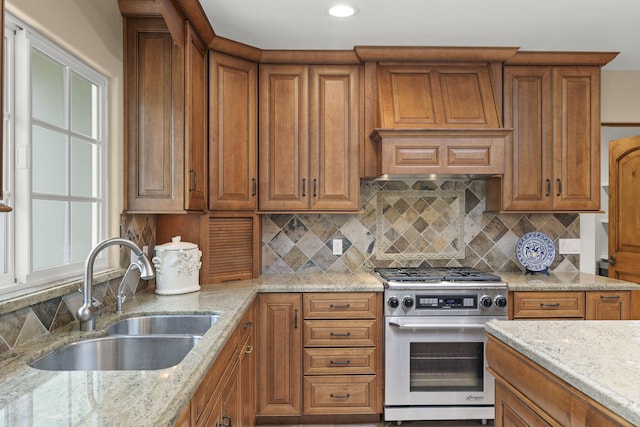 kitchen featuring brown cabinets, gas range, and a sink
