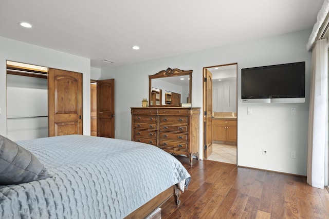 bedroom featuring hardwood / wood-style flooring, a closet, ensuite bathroom, and recessed lighting