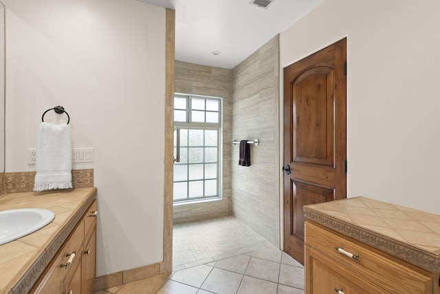 bathroom featuring tile patterned flooring, baseboards, vanity, and visible vents