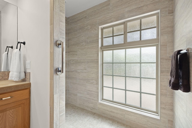bathroom featuring walk in shower and vanity