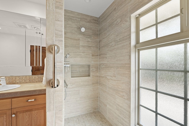 full bath featuring vanity and a tile shower