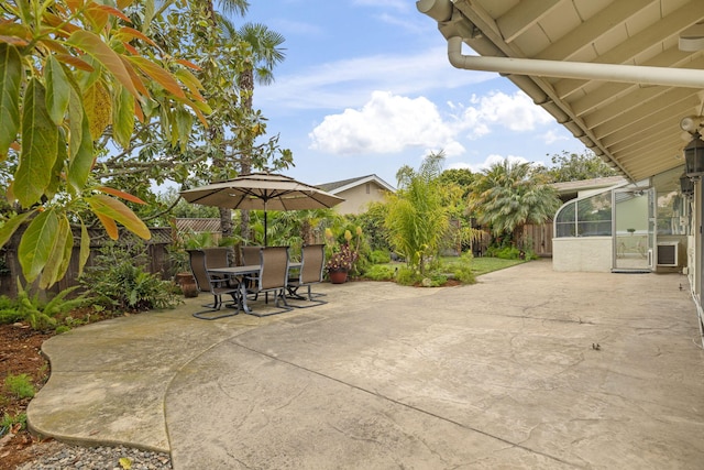 view of patio featuring a fenced backyard, a sunroom, and outdoor dining area