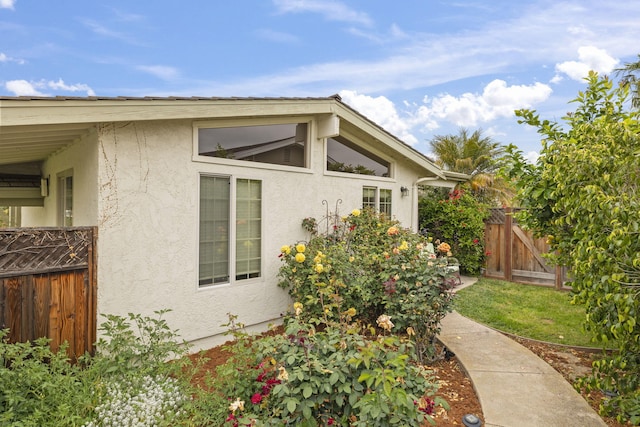 view of home's exterior featuring stucco siding and fence