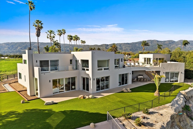 back of property with a patio, a fenced backyard, a mountain view, and stucco siding